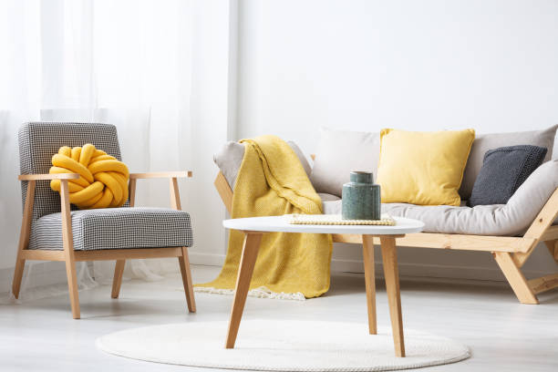 istock Patterned armchair next to settee with yellow blanket in flat interior with wooden table. Real photo 1040404282