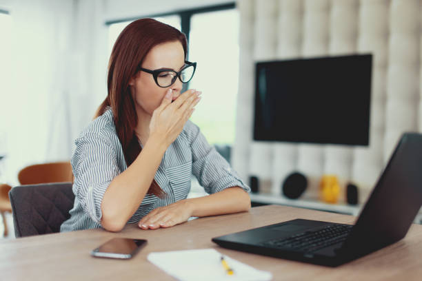 istock Tired freelancer woman yawning at laptop 1040404328