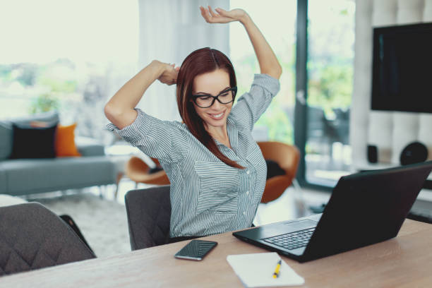 istock Young tired freelancer woman stretching at laptop 1040404358