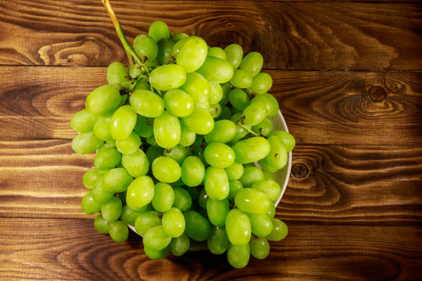 istock Tasty fresh white grape in a plate on wooden table 1040404376