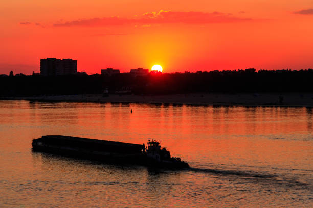 istock Tugboat pushing a heavy long barge on the river Dnieper at sunset 1040404560