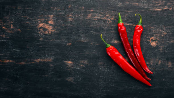 istock Chili red pepper. On a black wooden background. Free space for text. Top view. 1040408038