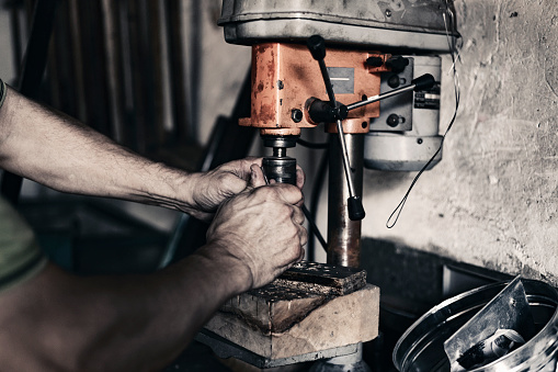 Cropped Image of Craftsman worker in his workshop working on his new project. Self-employed manual worker starting small business repair shop. Manual worker on a workshop with natural light. Close up shot of old master working in his workshop