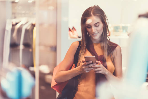 istock Woman in the clothing store using smartphone 1040414886