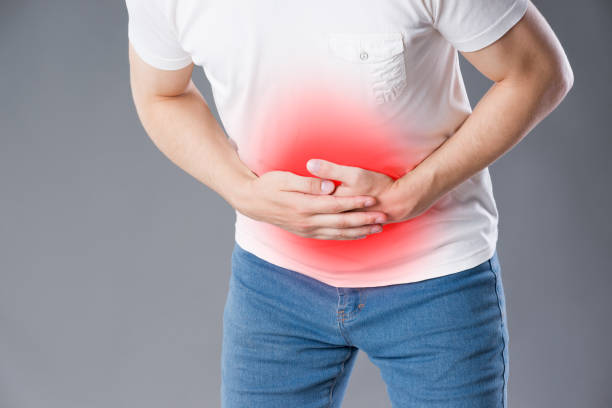 istock Man with abdominal pain, stomach ache on gray background 1040422822