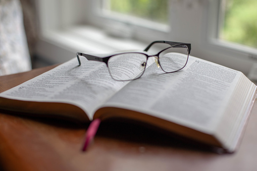 Open Bible and a pair of eyeglasses.