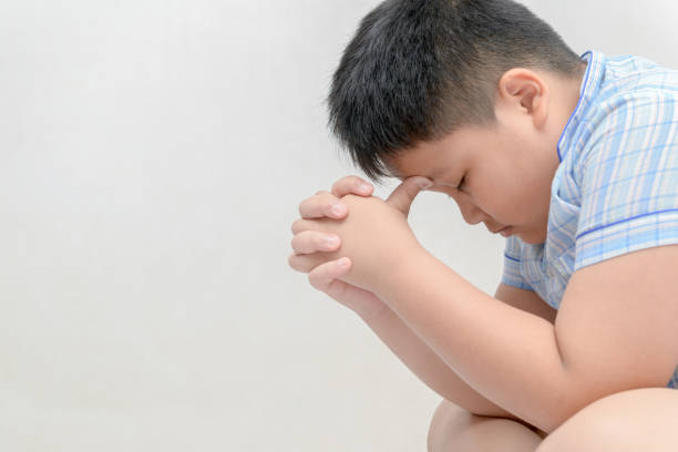fat boy is stress and headache. fat boy is stress and headache. distress, negative emotions concept overweight child fat sadness stock pictures, royalty-free photos & images