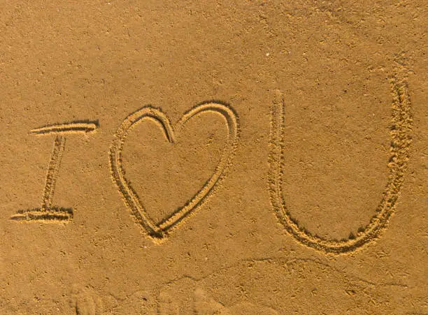 I love you written on sand at the beach