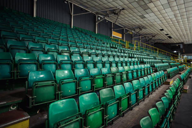 Empty rows of folding chairs in a ice rink. There are no people visible.