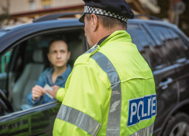 Police man giving a speeding ticket Man and woman, police officer making a traffic stop on the street. traffic fine stock pictures, royalty-free photos & images