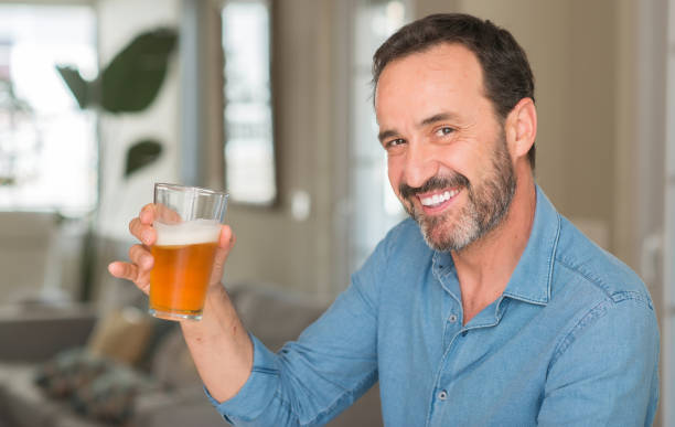 istock Middle age man drinking beer with a happy face standing and smiling with a confident smile showing teeth 1040454746