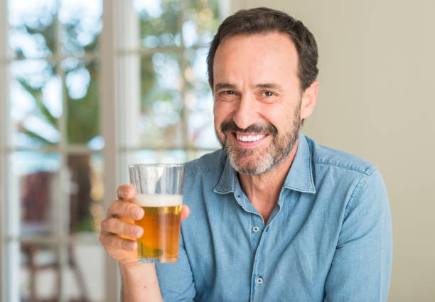 istock Middle age man drinking beer with a happy face standing and smiling with a confident smile showing teeth 1040454796