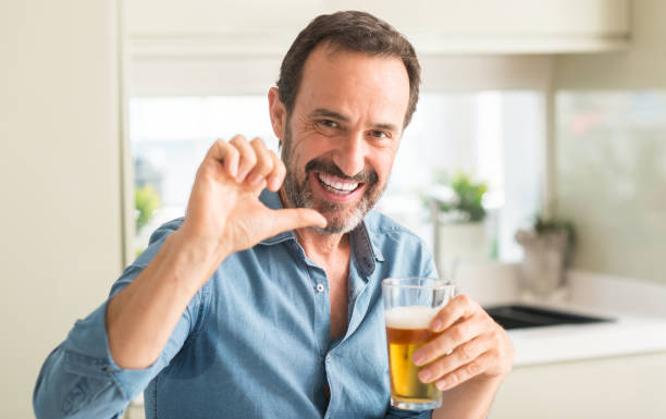 istock Middle age man drinking beer pointing with hand and finger up with happy face smiling 1040454854