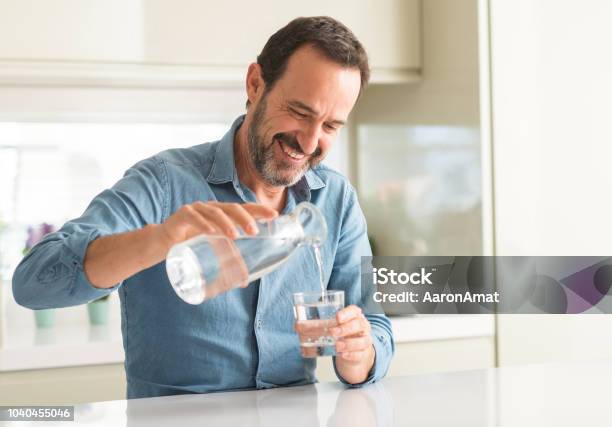 Man Van Middelbare Leeftijd Drinken Van Een Glas Water Met Een Blij Gezicht Permanent En Lachend Met Een Vertrouwen Glimlach Weergeven Tanden Stockfoto en meer beelden van Water