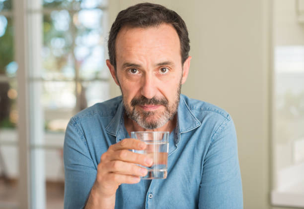 istock Middle age man drinking a glass of water with a confident expression on smart face thinking serious 1040455062