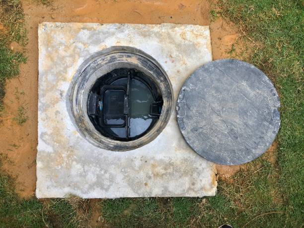 A hole of grease trap underground tank with the drain system around the house. stock photo