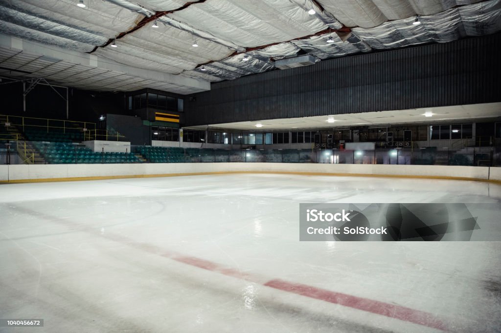 Empty Ice Rink Wide angle view of an interior of an empty ice rink. There are no people in the seats or on the ice. Ice Hockey Rink Stock Photo