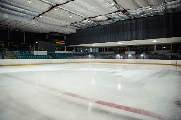 Wide angle view of an interior of an empty ice rink. There are no people in the seats or on the ice.