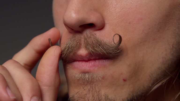 Close up man stroking mustache