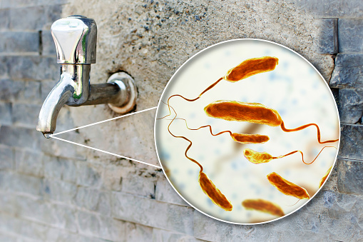 Safety of drinking water concept, 3D illustration showing bacteria Vibrio cholerae, the causative agent of cholera disease, contaminating drinking water