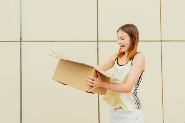 istock Cheerful young woman opening a cardboard box 1040472750