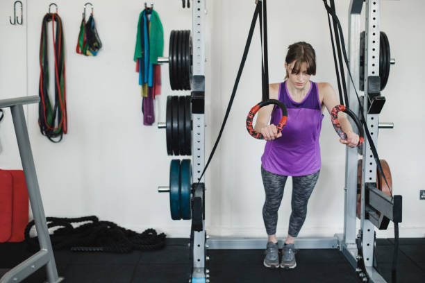 Young Woman Using Olympic Rings at the Gym