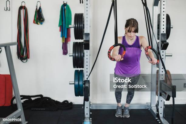 Young Woman Using Olympic Rings At The Gym Stock Photo - Download Image Now - 20-24 Years, Active Lifestyle, Adult