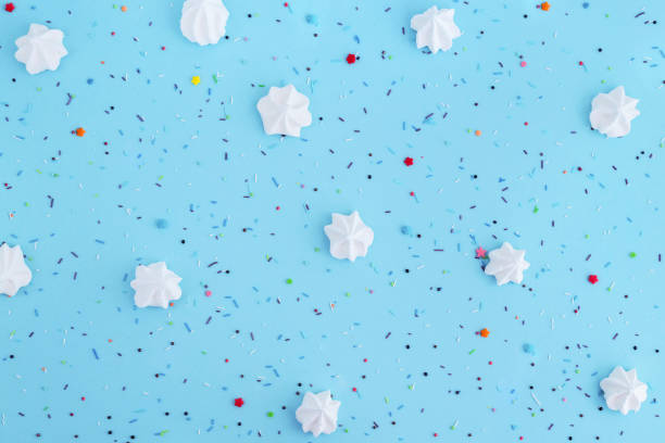 istock White meringues and colorful confetti on blue background. 1040499438