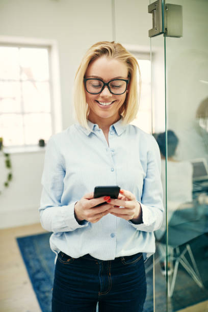 istock Young businesswoman standing in an office sending a text message 1040499536