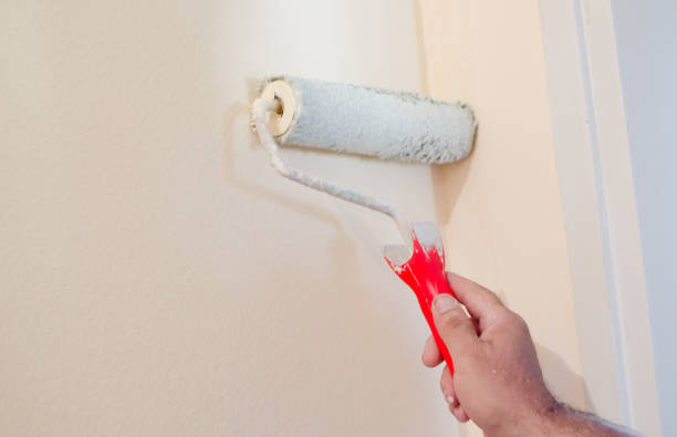istock Male hand painting wall with paint roller 1040501780