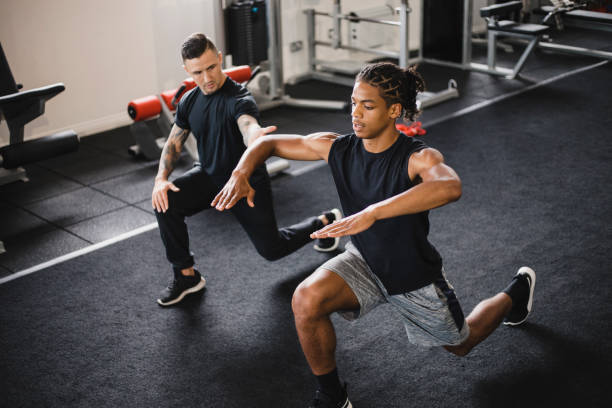 личная демонстра�ция обучения - gym muscular build weights two people стоковые фото и изображения