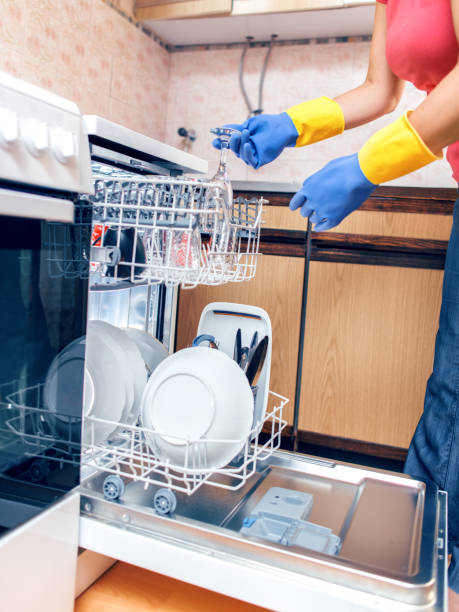 istock Woman taking out clean dishes from dishwasher machine 1040504226