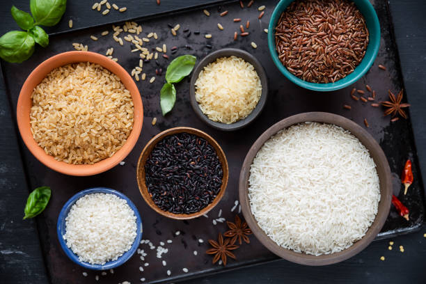 Variety of rice types in different bowls stock photo