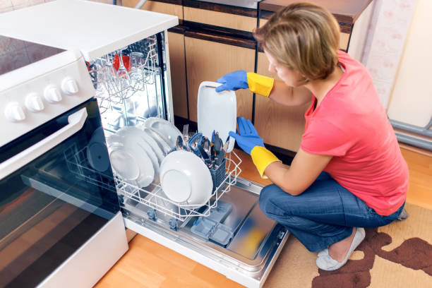 istock Woman taking out clean dishes from dishwasher machine 1040509138
