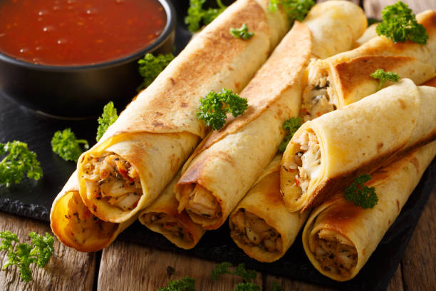 istock Mexican taquitos with chicken and chili sauce close-up. horizontal 1040509528