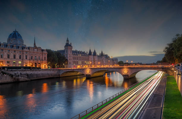 Stars over Seine River with Conciergerie and Notre Dame Bridge in Paris, France. stock photo