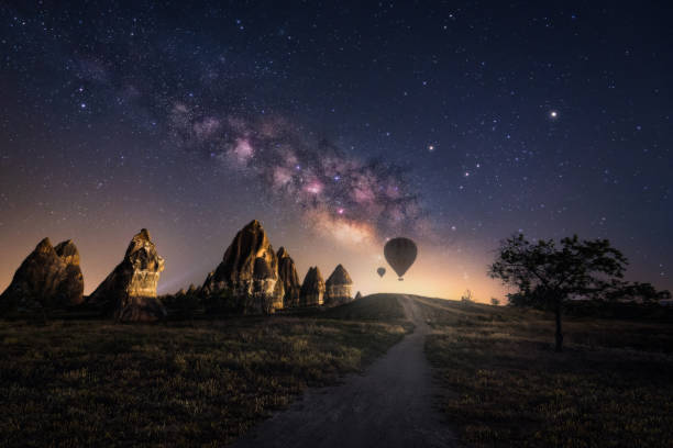 Fairy Chimneys With Milky Way And Hot Air Ballons At Cappadocia, Goreme, Turkey stock photo