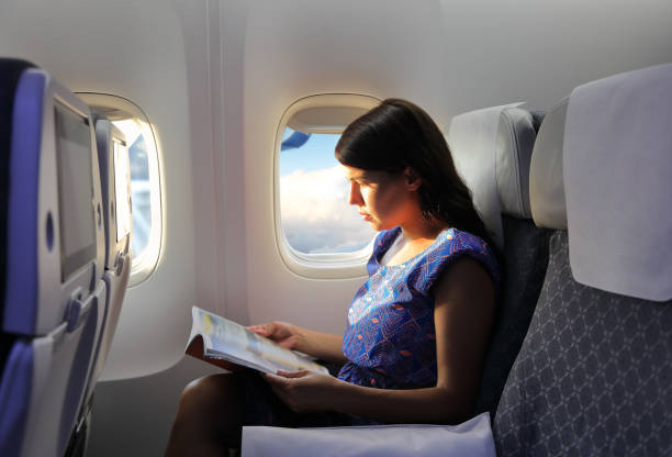 istock Young woman reading magazine during the flight 1040526396