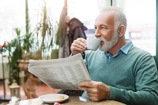 istock Senior man with newspaper drinking coffee 1040527778