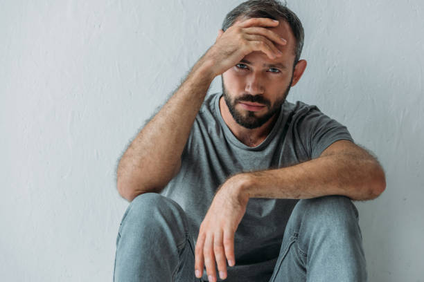 istock upset mid adult man sitting with hand on forehead and looking at camera 1040530308