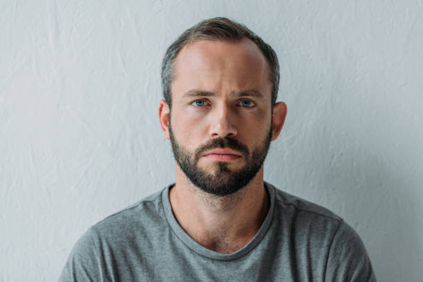 istock portrait of unhappy bearded man looking at camera on grey 1040530484