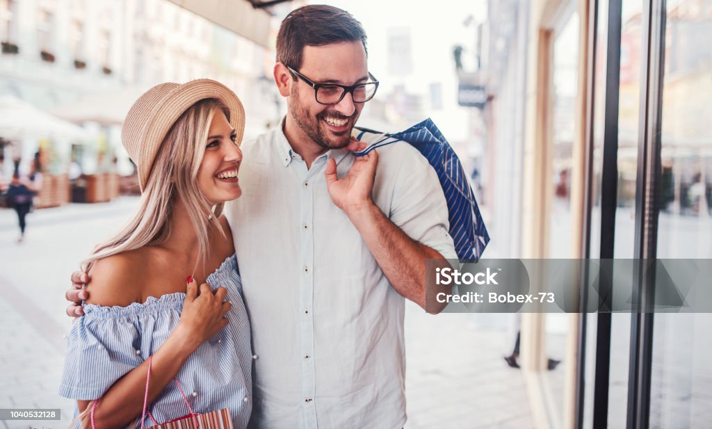Shopping time. Young couple in shopping. Consumerism, love, dating, lifestyle concept Beautiful young couple enjoying in shopping, having fun together in the city. Consumerism, love, dating, lifestyle concept Shopping Stock Photo