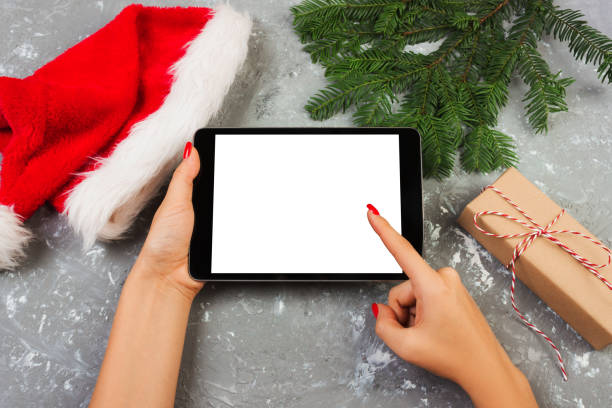 istock girl using tablet technology in home, person holding computer on background Christmas decoration, female hands texting, mockup templates 1040540416