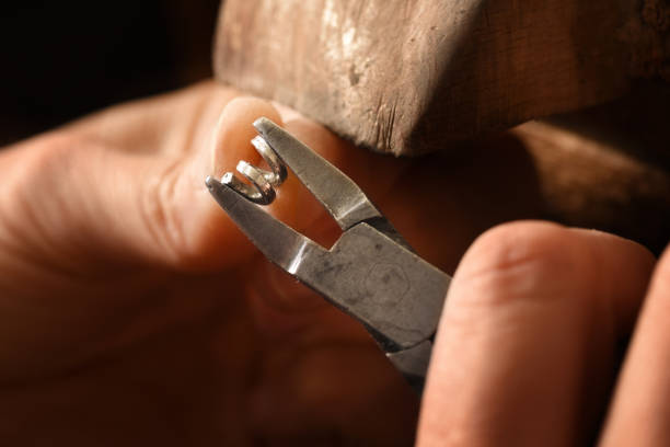 istock goldsmith hands working on a silver wire spiral with pliers small chain rings, macro shot with copy space 1040544054