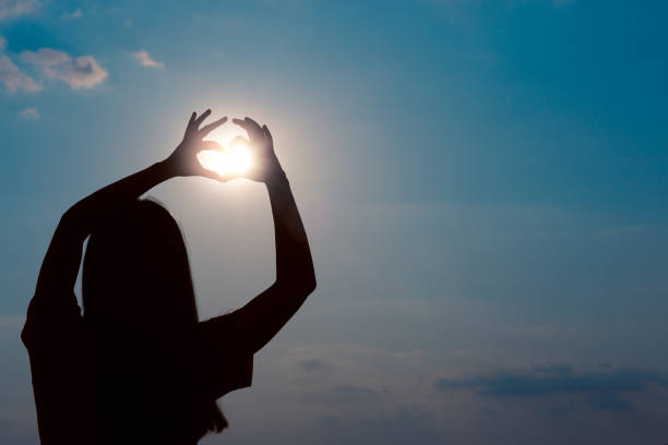 istock Woman Making Heart Sign Gesture in Sunset Sunlight 1040544430