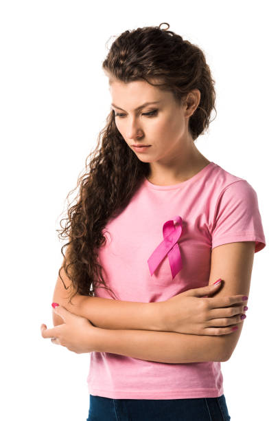 молодая женщина с розовой лентой стоял со скрещенными руками и глядя вниз изолированы на белом, рак молочной железы концепции - breast cancer pink ribbon alertness стоковые фото и изображения