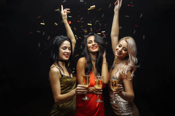jeunes femmes séduisantes célébrer une fête, boire du champagne et la danse. - soirée entre filles temps libre photos et images de collection