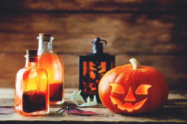 istock Glowing pumpkin with jars on dark wood background. Halloween concept 1040570270