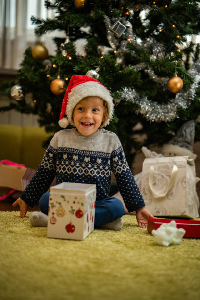 istock Cute boy opening gift on Christmas eve 1040570338