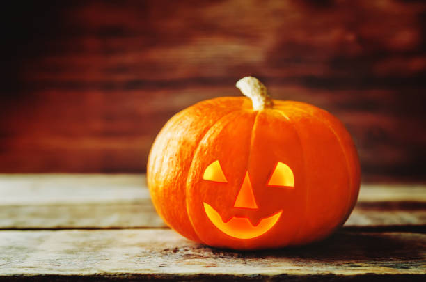 istock Glowing pumpkin on dark wood background. Halloween concept 1040570492